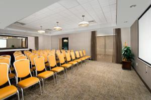 a conference room with orange chairs and a screen at SpringHill Suites by Marriott Jacksonville North I-95 Area in Jacksonville