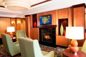 een hotelkamer met een open haard en een televisie bij Fairfield Inn & Suites Des Moines Airport in Des Moines