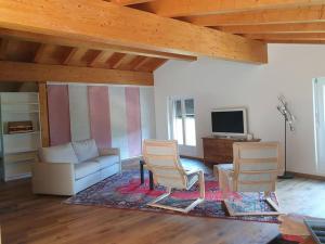 ein Wohnzimmer mit 2 Stühlen und einem Sofa in der Unterkunft Mansarda / Loft open space in Signora