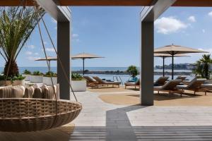 a patio with chairs and umbrellas and the water at JW Marriott Hotel Istanbul Marmara Sea in Istanbul