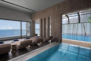 a pool in a hotel room with chairs and a swimming pool at JW Marriott Hotel Istanbul Marmara Sea in Istanbul
