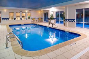 a pool in a hotel with blue water at Fairfield Inn & Suites Greensboro Wendover in Greensboro