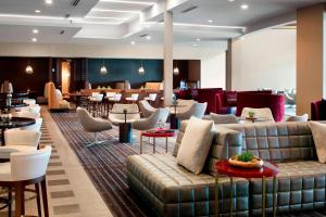um átrio do hotel com um sofá, mesas e cadeiras em Marriott Columbus OSU em Columbus