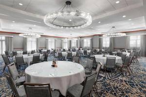 una sala de banquetes con mesas y sillas blancas y lámparas de araña en Residence Inn Austin Downtown / Convention Center, en Austin