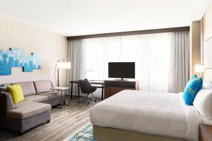 a hotel room with a bed and a couch and a desk at Residence Inn by Marriott Dallas Downtown in Dallas