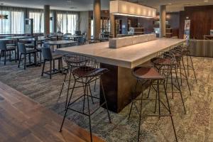 a bar with stools around it in a restaurant at Courtyard by Marriott Troy in Troy