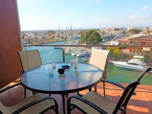 a table on a balcony with a view of a harbor at Global Immo 3360 LES MARINES GARBI 4-2 in Roses