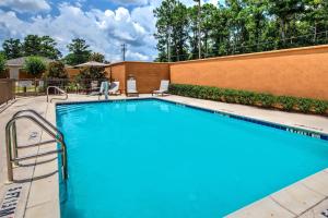 a large swimming pool with chairs and a fence at Courtyard by Marriott Troy in Troy