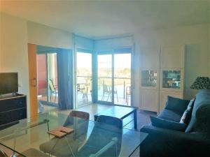 a living room with a glass table and a couch at Global Immo 3360 LES MARINES GARBI 4-2 in Roses