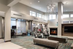 una gran sala de estar con chimenea y sillas. en Residence Inn by Marriott Dallas Plano/Richardson at Coit Rd., en Plano