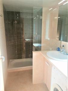 a bathroom with a shower and a sink and a tub at Global Immo 3360 LES MARINES GARBI 4-2 in Roses