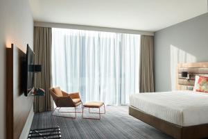 um quarto de hotel com uma cama e uma cadeira em Moxy Dublin City em Dublin