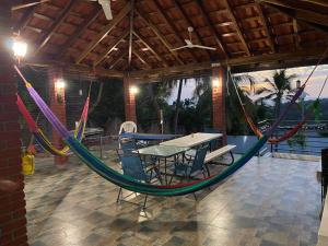 um pátio com uma mesa, cadeiras e uma rede de descanso em Habitaciones Casa Cuscatlan em Tamanique