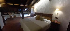 a bedroom with a bed and a table and chairs at La Casona de Revolgo in Santillana del Mar