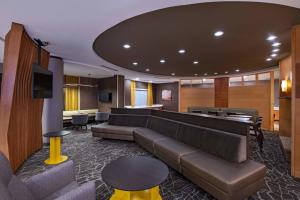 a lobby with a couch and a tv and tables at SpringHill Suites Boise West/Eagle in Boise