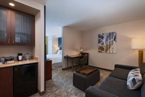 ein Wohnzimmer mit einem Sofa und ein Zimmer mit einem Bett in der Unterkunft SpringHill Suites Boise West/Eagle in Boise