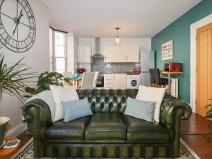 un sofá de cuero en una sala de estar con cocina en Blue Skies, en Ilfracombe