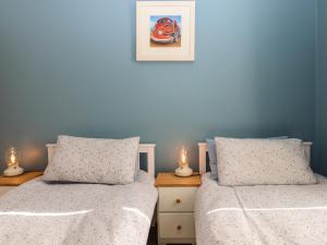 2 camas en un dormitorio con paredes azules en Blue Skies, en Ilfracombe