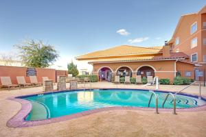 a swimming pool with chairs and a building at Residence Inn Midland in Midland