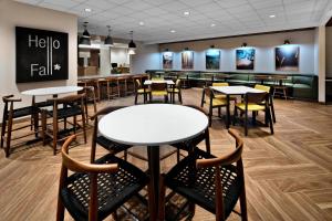 a restaurant with tables and chairs and a bar at Fairfield Inn & Suites Columbus New Albany in New Albany