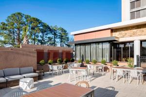 un patio con mesas y sillas frente a un edificio en North Charleston Marriott en Charleston