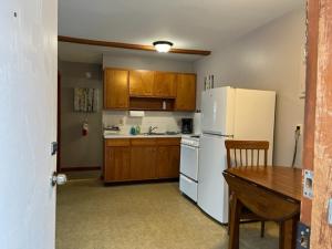a kitchen with a white refrigerator and a wooden table at Little Bluff Inn in Trempealeau