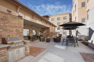 um pátio exterior com comodidades para churrascos e um guarda-sol em Residence Inn Grand Junction em Grand Junction