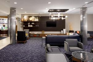 a lobby with a waiting room with chairs and a tv at Courtyard by Marriott Boone in Boone