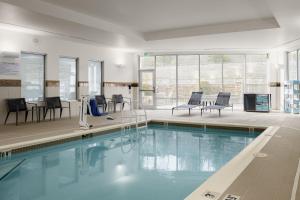 a pool with chairs and tables in a building at Courtyard by Marriott Boone in Boone