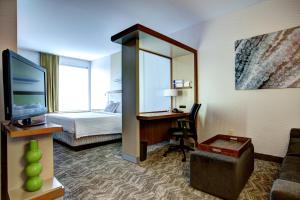 Habitación de hotel con cama y escritorio con TV. en SpringHill Suites Harrisburg Hershey, en Harrisburg