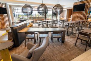 a restaurant with tables and chairs and a bar at SpringHill Suites by Marriott Ontario Airport/Rancho Cucamonga in Ontario