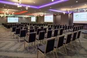 a row of chairs in a room with a projection screen at Aloft North Kansas City in Kansas City