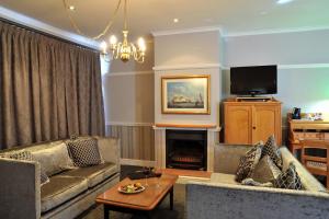 a living room with a couch and a fireplace at Cumberland Hotel Worcester in Worcester