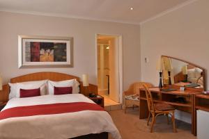 a bedroom with a bed and a desk with a mirror at Cumberland Hotel Worcester in Worcester