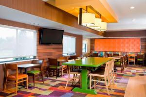 a restaurant with tables and chairs and a flat screen tv at Fairfield Inn & Suites Lexington Keeneland Airport in Lexington