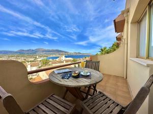 een tafel en stoelen op een balkon met uitzicht op de oceaan bij Albir Hills Apartments in Albir