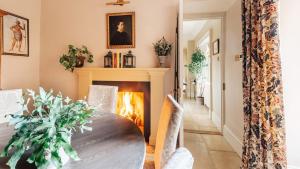 a dining room with a table and a fireplace at Singer House in Chipping Campden