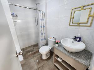 W łazience znajduje się umywalka, toaleta i lustro. w obiekcie Dpto acogedor con terraza privada w mieście Lima