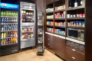 a grocery store aisle with drinks and a refrigerator at Courtyard Greenville Haywood Mall in Greenville