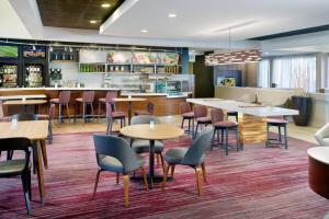 a restaurant with tables and chairs and a bar at Courtyard Greenville Haywood Mall in Greenville