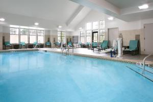 a swimming pool with chairs and tables in a building at Residence Inn by Marriott Lincoln South in Lincoln