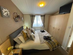 a small bedroom with a bed in a room at Rudd lake Luxury lakeside lodge with fishing & hot tub@Tattershall in Tattershall