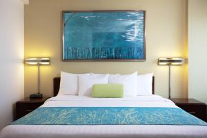 a bed in a hotel room with two lamps at SpringHill Suites Los Angeles LAX/Manhattan Beach in Hawthorne