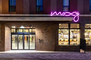 a neon sign on the side of a store at Moxy Dortmund City in Dortmund