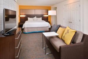 a hotel room with a bed and a couch and a television at Residence Inn by Marriott Boise Downtown/University in Boise