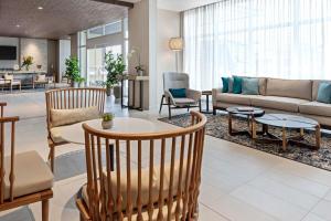a living room with a couch and a table and chairs at Fairfield by Marriott San Jose Airport Alajuela in Alajuela City
