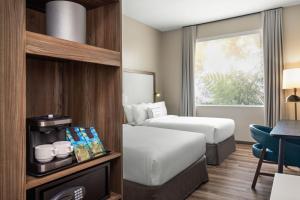 a hotel room with two beds and a window at Fairfield by Marriott San Jose Airport Alajuela in Alajuela City