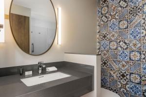 a bathroom with a sink and a mirror at Fairfield by Marriott San Jose Airport Alajuela in Alajuela City
