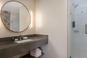 a bathroom with a sink and a mirror at Fairfield by Marriott San Jose Airport Alajuela in Alajuela City