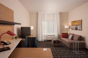 a living room with a couch and a tv at TownePlace Suites by Marriott Charleston Airport/Convention Center in Charleston